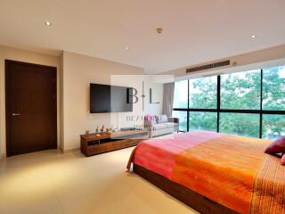 Spacious and well-lit bedroom with large windows and modern furnishings