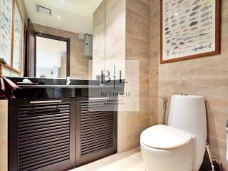 Modern bathroom with large mirror, black countertop, and fish-themed wall art