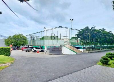 Tennis courts by a parking space and landscaped area