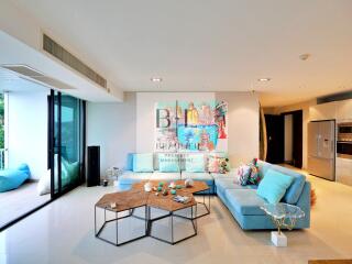 Modern living room with blue sofa, artwork, and hexagonal coffee table