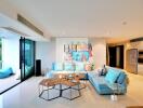Modern living room with blue sofa, artwork, and hexagonal coffee table