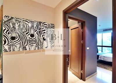 Hallway with zebras artwork leading to bedroom and other rooms