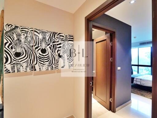 Hallway with zebras artwork leading to bedroom and other rooms