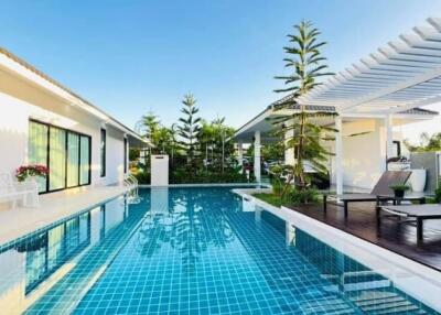 Outdoor pool area with lounge chairs and a pergola