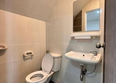 Bathroom with toilet, sink, and mirror