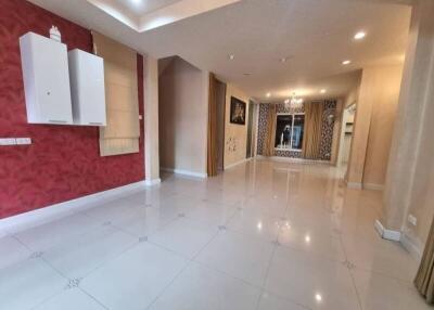 Spacious living room with red accent wall and large windows