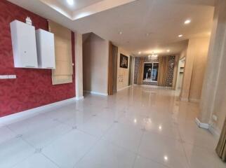 Spacious living room with red accent wall and large windows