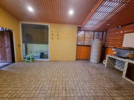 Spacious patio area with tiled floor and wooden ceiling