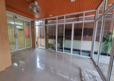 Spacious glass-enclosed living area with tiled flooring