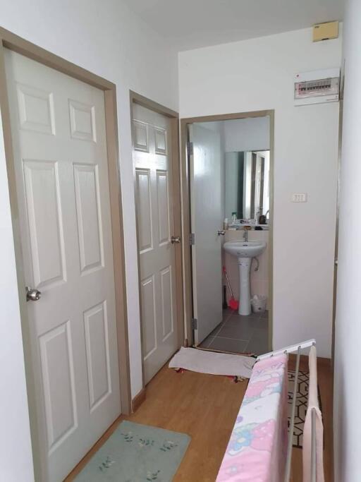 Hallway with doors leading to bathroom and rooms