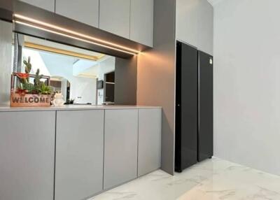 Modern kitchen with sleek gray cabinetry and welcome sign