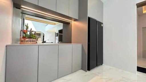 Modern kitchen with sleek gray cabinetry and welcome sign