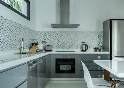 Modern kitchen with white and gray color scheme, stainless steel appliances, and mosaic tile backsplash