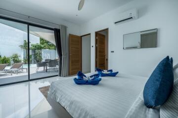 Modern bedroom with large sliding doors leading to a patio