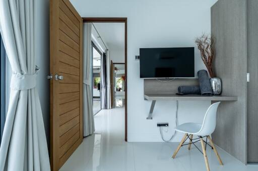 Modern bedroom with wall-mounted TV and a minimalist desk