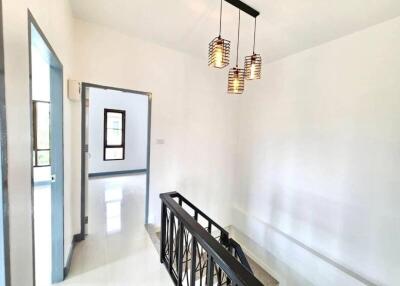 Bright hallway with staircase and modern light fixture