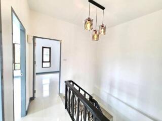 Bright hallway with staircase and modern light fixture