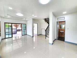 Bright and spacious living area with large windows and staircase