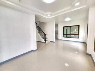 Spacious modern living room with tiled flooring and staircase