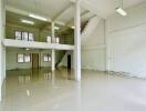 Spacious multi-level commercial space with large windows and polished tile floors.