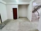 Empty room with concrete floor and stairway