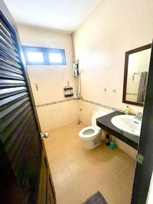 Bathroom with toilet, sink, and mirror