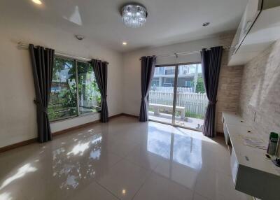 Spacious and well-lit living room with large windows and modern lighting.