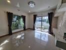 Spacious and well-lit living room with large windows and modern lighting.