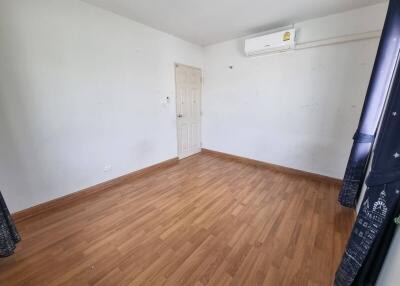 Empty bedroom with hardwood floor and air conditioner