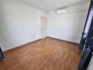 Empty bedroom with hardwood floor and air conditioner