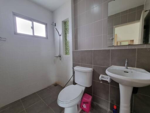 Modern bathroom with sink, toilet, shower, and window