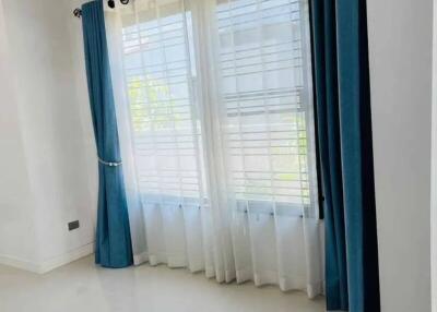 Bedroom with large window, blue curtains, and air conditioner