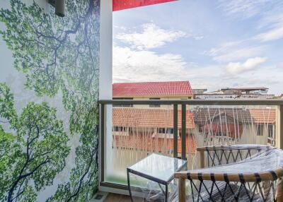 Balcony with outdoor seating and view of neighboring roofs