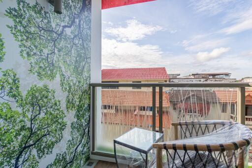 Balcony with outdoor seating and view of neighboring roofs