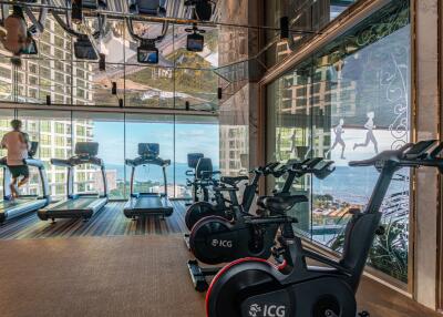 Modern fitness center with cardio equipment and city view