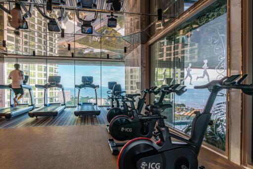 Modern fitness center with cardio equipment and city view