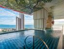 Infinity pool with a scenic view of the ocean and city buildings