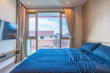 modern bedroom with large window and blue bedding