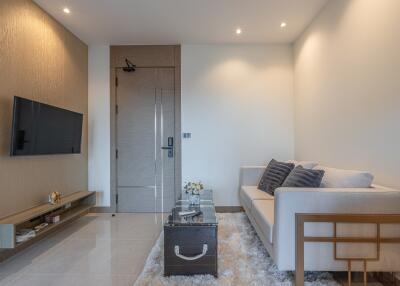 Contemporary living room with modern decor, wall-mounted TV, and plush seating