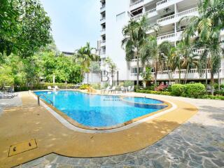 Swimming pool with surrounding patio and greenery