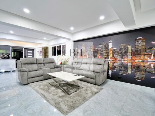 Modern living room with cityscape wall art and gray sofas