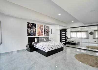 Modern and spacious bedroom with large bed and mirrored closet