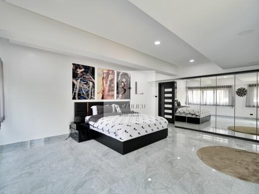 Modern and spacious bedroom with large bed and mirrored closet