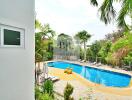 Swimming pool area with lounge chairs and greenery