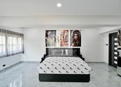 Spacious modern bedroom with unique artwork and ample natural light