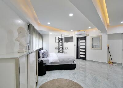 Modern bedroom with grey bed, marble flooring, and ceiling lights