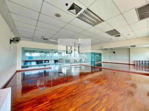 Spacious open floor area with wooden flooring and large mirrors