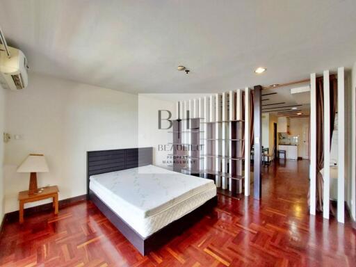 Bedroom with large bed and wooden flooring