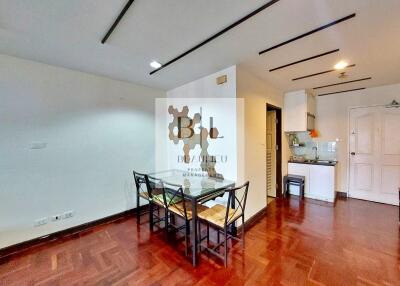 Modern living and dining area with hardwood floors and a view of the kitchen