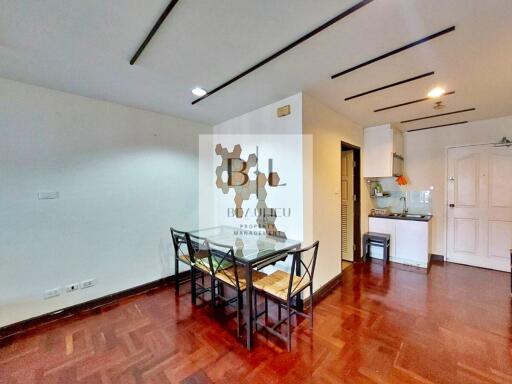 Modern living and dining area with hardwood floors and a view of the kitchen